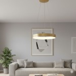 Lampa wisząca Giulia D48 LED, 1-punktowa, w kolorze złotym. Okrągła konstrukcja z białym kloszem, zawieszona na cienkich linkach. Umieszczona w nowoczesnym wnętrzu, nad szarym sofą, w towarzystwie rośliny doniczkowej.