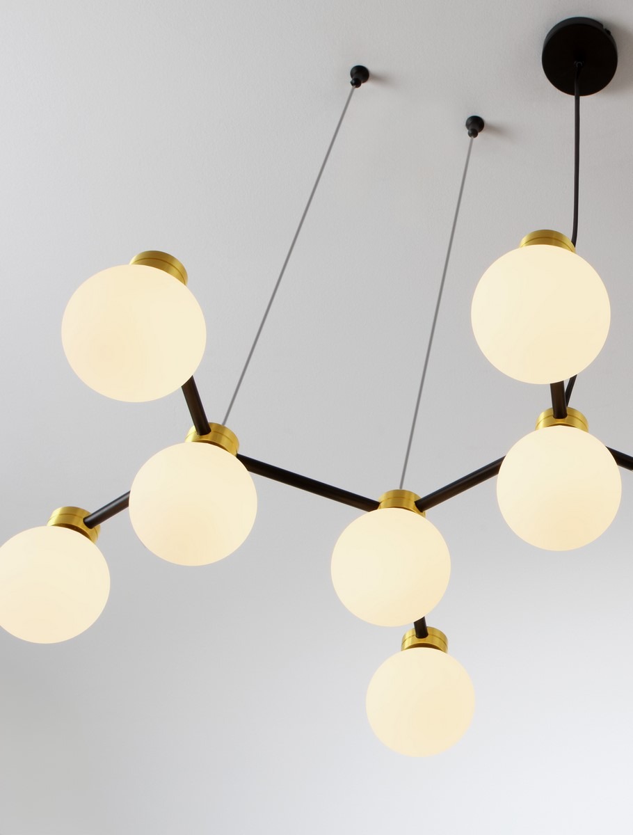 Lampa wisząca Caminos 14xG9 w kolorze czarnym i złotym, z sześcioma białymi, okrągłymi kloszami. Ujęcie z dołu, pokazujące lampę zamontowaną na suficie, z widocznymi metalowymi elementami mocującymi i przewodami.