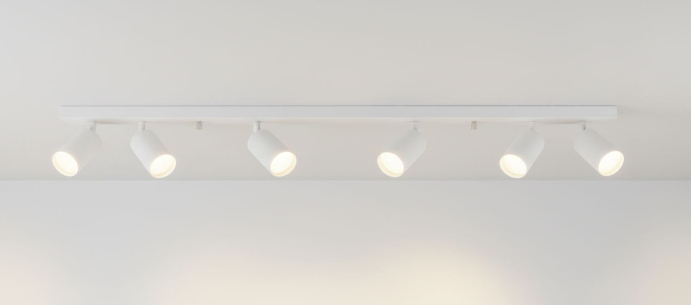Biała lampa sufitowa Spoti z sześcioma ruchomymi punktami świetlnymi. Zamontowana na prostokątnej podstawie, z każdą lampą skierowaną w różne strony. Minimalistyczny design, idealna do nowoczesnych wnętrz.