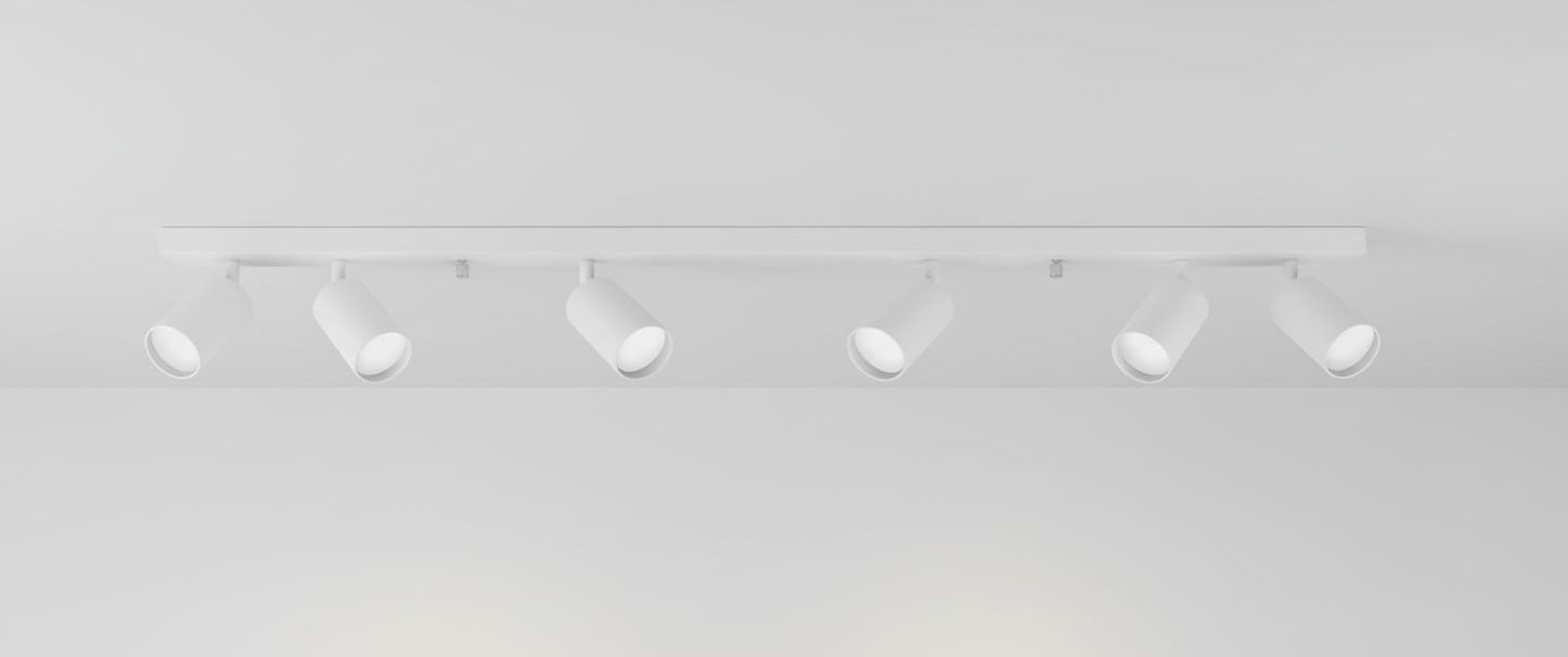 Biała lampa sufitowa typu spot, sześciopunktowa, zamontowana na prostokątnej podstawie. Ujęcie frontalne, widoczne trzy cylindryczne klosze z otwartymi końcami, skierowane w różnych kierunkach. Tło jasne, jednolite.