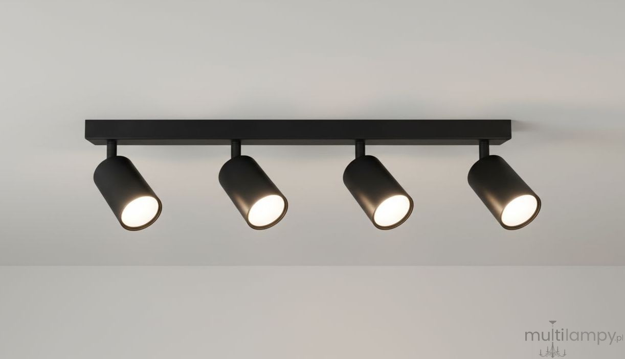 Czarna lampa sufitowa 4-punktowa z metalowymi reflektorami, zamontowana na prostokątnym stelażu. Reflektory są cylindryczne, skierowane w dół, na jednolitym tle.