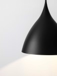 Lampa wisząca Chayanta w kolorze czarnym, z metalowym kloszem o kształcie stożka, z trzema gniazdami E27. Widok z góry, zbliżenie na detal klosza, emitującego światło w dół. Tło jasne, podkreślające minimalistyczny design.