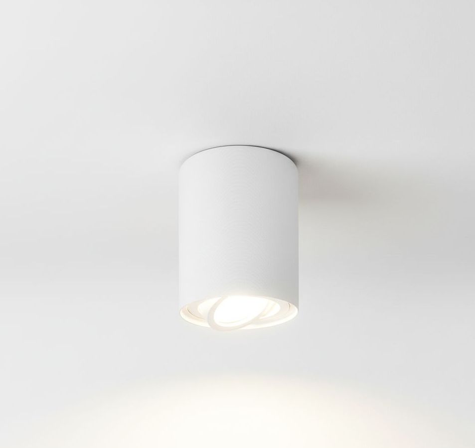 Lampa sufitowa Deba w kształcie tuby, biała, zamontowana na suficie. Okrągła, gładka obudowa z widoczną żarówką w środku, emitująca światło. Prosty design, idealna do nowoczesnych wnętrz.