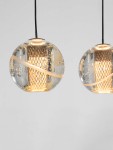 Lampa wisząca Cuyo z pięcioma źródłami LED 16W, w złotej kolorystyce. Szklane klosze w kształcie kul z bąbelkami, z metalowym wnętrzem w siatkę. Zawieszona na czarnym przewodzie, w stylowym, nowoczesnym designie.