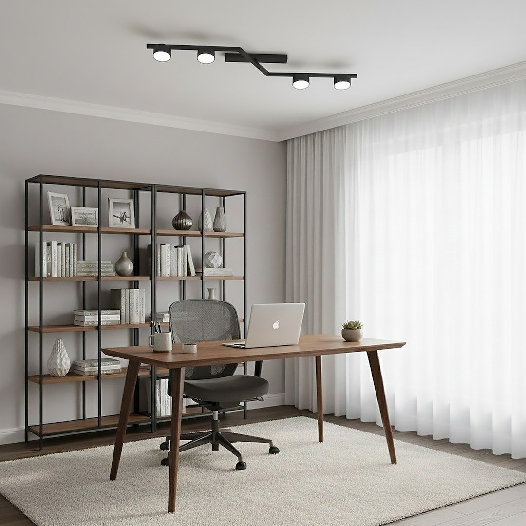 Lampa sufitowa Skan czarna z 4 punktami świetlnymi GX53, zamontowana na suficie, o nowoczesnym, minimalistycznym designie. Widoczna w jasnym pomieszczeniu z biurkiem, krzesłem i regałem w tle.