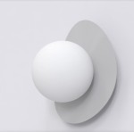 Ovo kinkiet 1xG9 w kolorze szarym, z zaokrągloną, matową osłoną w kształcie elipsy oraz białą, półkulistą żarówką. Produkt zamontowany na gładkiej, jasnej ścianie, ukazujący nowoczesny design z minimalistycznymi detalami.