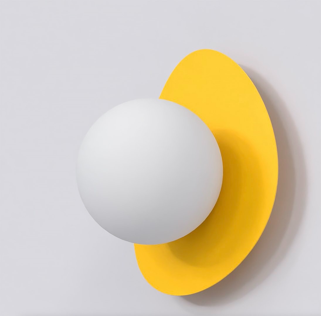 Kinkiet Ovo w kolorze pomarańczowym, z białą kulistą lampą i asymetrycznym, żółtym tłem. Produkt zamontowany na gładkiej, jasnej ścianie, widoczny z przodu. Okrągły kształt lampy oraz kontur tła tworzą nowoczesny design.