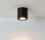 Czarna lampa sufitowa tuba Aqua IP54, zamontowana na suficie, z okrągłym źródłem światła widocznym w środku. Prosta, cylindryczna forma, idealna do łazienki, na jasnym tle.