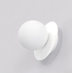 Biały kinkiet Americana 1xG9 z okrągłą, matową głowicą i płaską, okrągłą podstawą. Produkt zamontowany na gładkiej, jasnej ścianie, widok z przodu, podkreślający minimalistyczny design i nowoczesną formę.