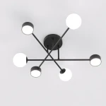 Lampa sufitowa Holon w kolorze czarnym, z sześcioma punktami świetlnymi na ramionach. Kształt geometryczny z białymi okrągłymi abażurami. Montaż na suficie, widok z dołu.