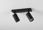 Czarna lampa sufitowa typu spot z dwoma reflektorami GU10. Reflektory posiadają teksturowaną, wieloboczną powierzchnię. Lampa zamontowana poziomo na prostokątnej podstawie. Idealna do nowoczesnych wnętrz.