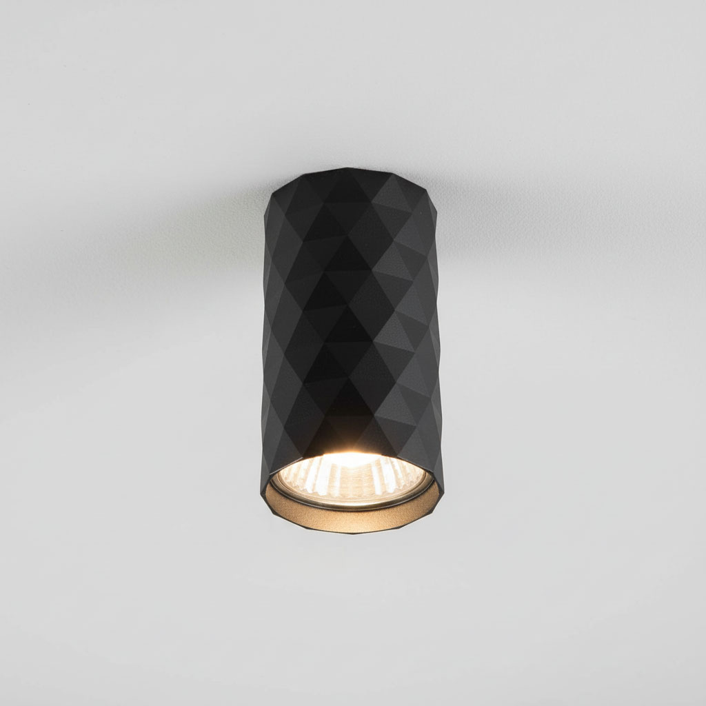 Czarna lampa sufitowa tuba GU10 z fakturą w kształcie diamentów. Ujęcie z góry, zamontowana na białym suficie, z widoczną żarówką wewnątrz. Elegancki design, idealna do nowoczesnych wnętrz.