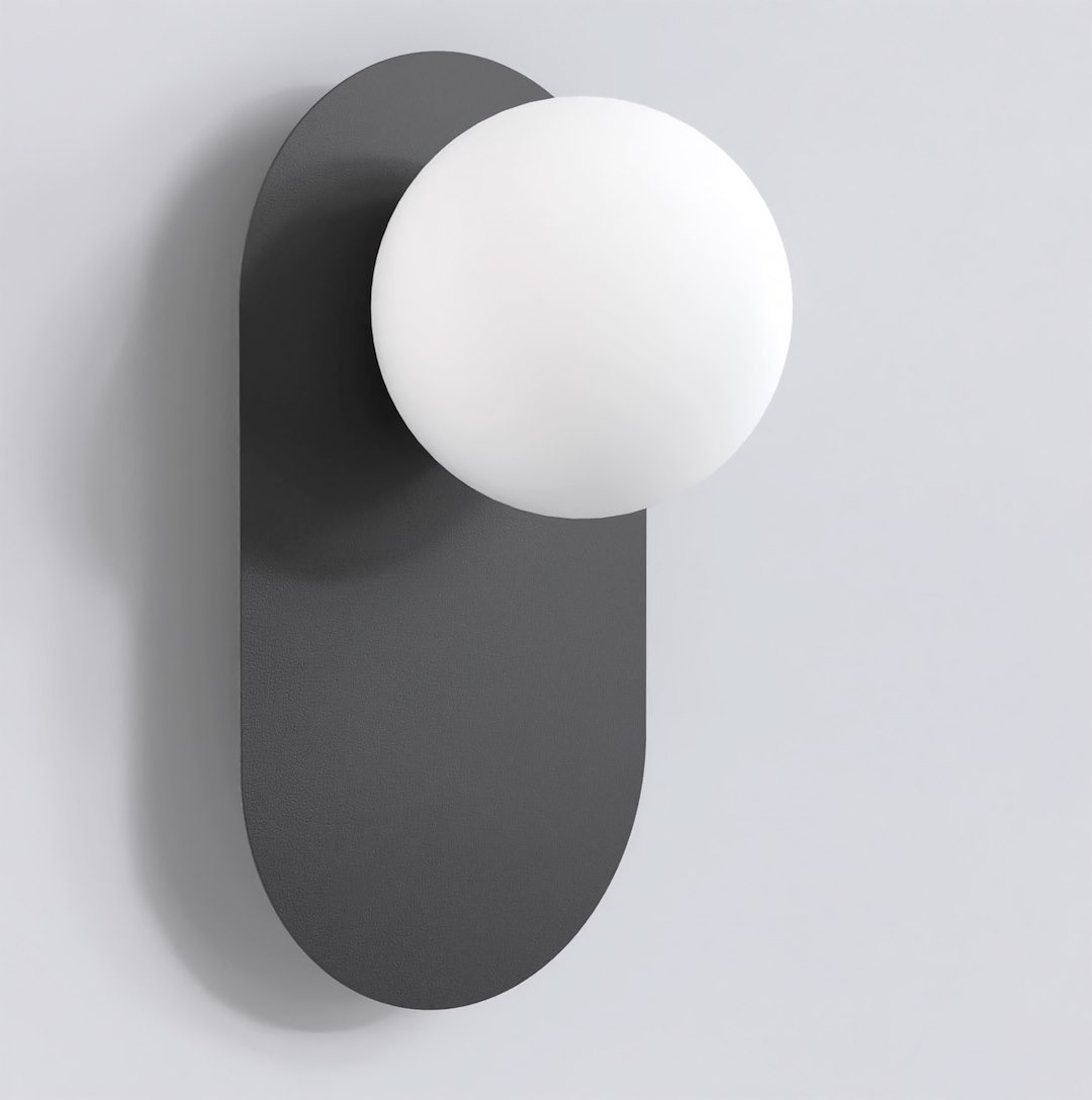 Kinkiet Viva w kolorze czarnym, z okrągłą, białą oprawą ze szkła. Zawieszony na prostokątnej, matowej podstawie. Produkt w ujęciu frontalnym, pokazujący minimalistyczny design i nowoczesne kształty.