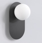 Kinkiet Viva w kolorze czarnym, z okrągłą, białą oprawą ze szkła. Zawieszony na prostokątnej, matowej podstawie. Produkt w ujęciu frontalnym, pokazujący minimalistyczny design i nowoczesne kształty.