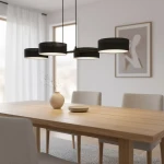 Lampa wisząca Drumz 4xE14 w kolorze czarnym, z czterema okrągłymi kloszami, zawieszona nad drewnianym stołem w jasnym wnętrzu. Widoczna dekoracyjna wazka i talerz na stole. Tło z oknami i zasłonami.