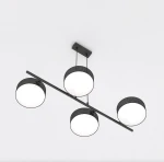 Lampa wisząca Drumz w kolorze czarnym z czterema okrągłymi kloszami LED, zawieszona na cienkiej metalowej rurce. Klosze mają białe, matowe wykończenie, a całość montowana jest do sufitu. Ujęcie z dołu, pokazujące równomierne rozmieszczenie kloszy.