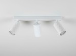 Lampa sufitowa spot z trzema reflektorami w kolorze białym, wykonana z materiału o fakturze diamentowej. Reflektory zamocowane na prostokątnym stelażu, skierowane w różnych kierunkach. Ujęcie z przodu, na jasnym tle.