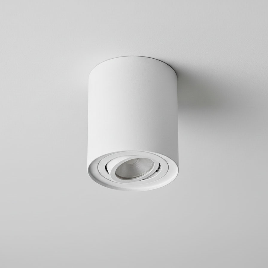 Lampa sufitowa Devo w białej obudowie, w kształcie tuby, z jednym gniazdem GU10. Zainstalowana na suficie, z widoczną soczewką wewnętrzną. Prosty, nowoczesny design, idealna do oświetlenia kierunkowego.