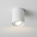 Biała lampa sufitowa w formie tuby, z zamontowanym źródłem światła GU10. Ujęcie z dołu, pokazujące okrągły kształt i wykończenie. Lampa kierunkowa, montowana na suficie, o minimalistycznym designie.