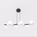Lampa wisząca model 1487/6 z sześcioma źródłami światła G9, w kolorze czarnym i białym. Konstrukcja z okrągłymi, białymi kloszami i czarnym, metalowym stelażem. Ujęcie z góry, wisząca pod sufitem.