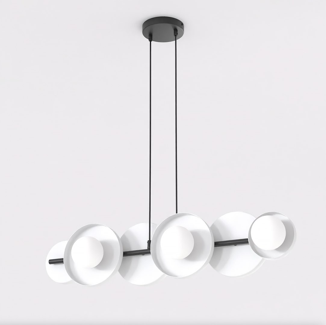 Lampa wisząca Model 6xG9 w czarnej i białej kolorystyce, z sześcioma okrągłymi kloszami na długich przewodach. Klosze z białego materiału z centralnymi źródłami światła, montowana na suficie. Prosta, nowoczesna forma.
