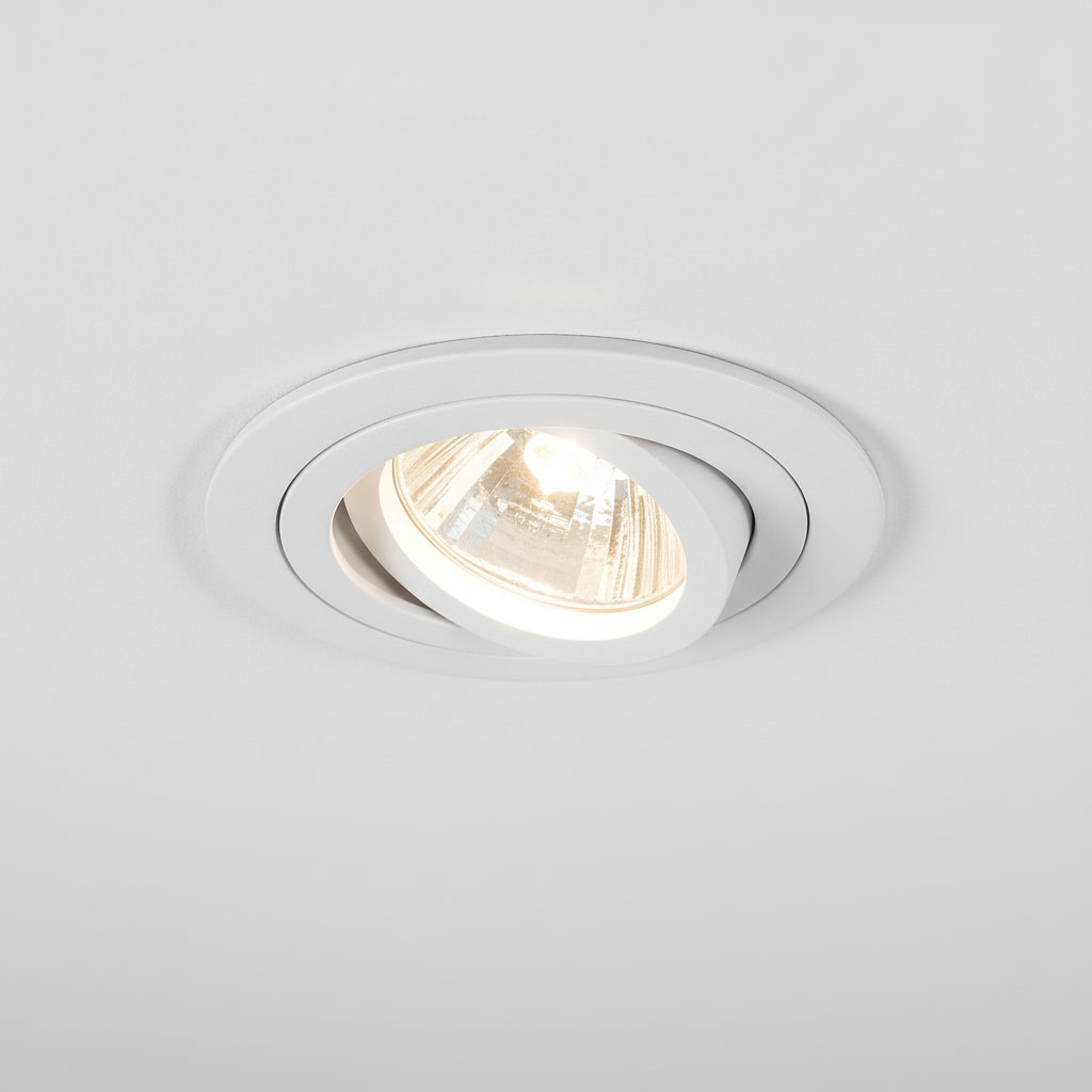 Oprawa podtynkowa ruchoma GU10 w kolorze białym, zamontowana w suficie. Widać lekko wypukłą obudowę z metalicznym wykończeniem oraz źródło światła w centralnej części, emitujące jasne światło.