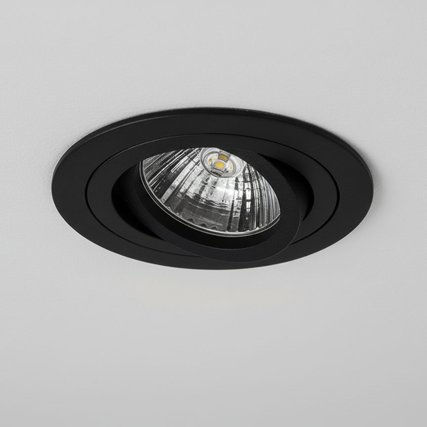 Ruchoma oprawa podtynkowa GU10 w kolorze czarnym, zamontowana w suficie, z widoczną szklaną żarówką w kształcie stożka. Oprawa ma okrągły kształt i matowe wykończenie, co podkreśla nowoczesny styl.