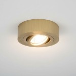 Ruchoma, podtynkowa oprawa oświetleniowa w kolorze złotym, okrągła, z gładką powierzchnią. Zainstalowana w suficie, emitująca ciepłe światło. Widoczny reflektor w centralnej części, otoczony elegancką ramką.