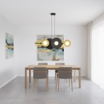Lampa wisząca Volum w kolorze czarnym i złotym, z sześcioma źródłami światła G9. Zawieszona nad prostokątnym drewnianym stołem w jasnym wnętrzu. Elementy okrągłe i owalne, zróżnicowane w kształcie, tworzą nowoczesny design.