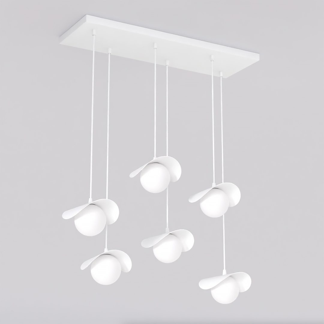 Lampa wisząca Ritual w kolorze białym, z sześcioma źródłami światła G9. Okrągłe klosze z płaskimi osłonami, zawieszone na cienkich linkach z prostokątną podstawą. Ujęcie frontalne, na szarym tle.