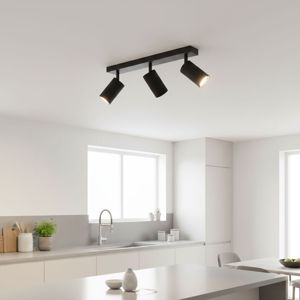 Lampa sufitowa Lucerno w kolorze czarnym z trzema reflektorami GU10, zamontowana na prostokątnej podstawie. Ujęcie z góry, w nowoczesnej kuchni, z białymi ścianami i dużym oknem w tle.