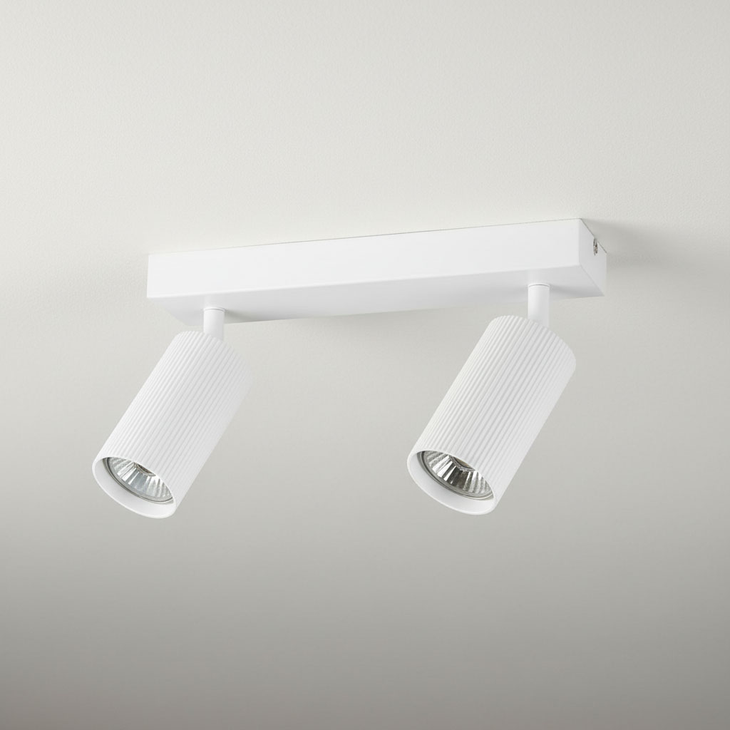 Lampa sufitowa Lucerno z dwoma reflektorami, w kolorze białym. Posiada cylindryczne klosze z teksturowanej powierzchni, zamontowane na prostokątnej podstawie. Klosze są skierowane w różnych kierunkach, co umożliwia kierunkowe oświetlenie.