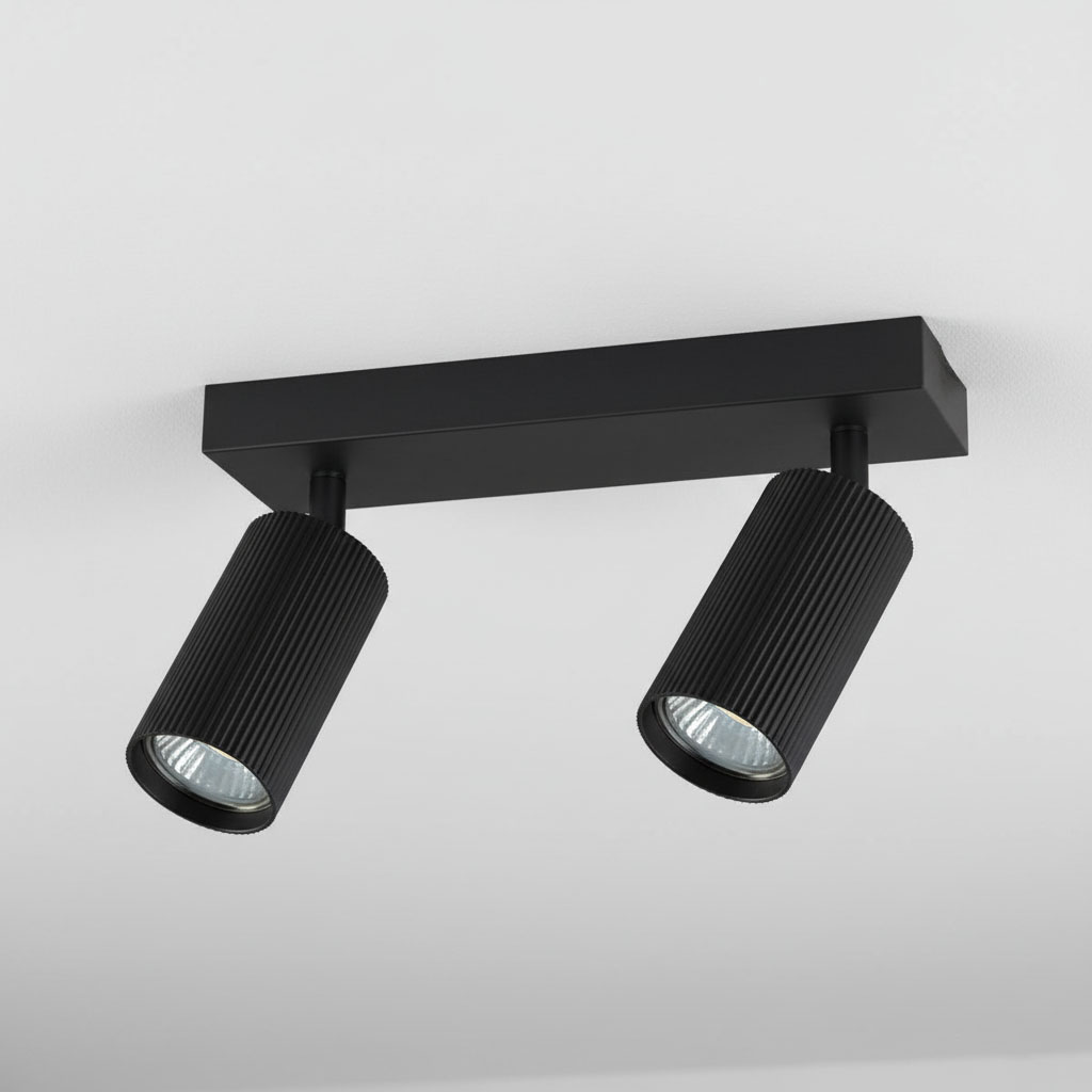 Lampa sufitowa Lucerno w kolorze czarnym, z dwoma reflektorami GU10. Reflektory mają ryflowaną powierzchnię, zamocowane na prostokątnej podstawie. Ujęcie z dołu, pokazujące iluminację w górę, na tle jasnego sufitu.