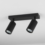 Lampa sufitowa Lucerno w kolorze czarnym, z dwoma reflektorami GU10. Reflektory mają ryflowaną powierzchnię, zamocowane na prostokątnej podstawie. Ujęcie z dołu, pokazujące iluminację w górę, na tle jasnego sufitu.
