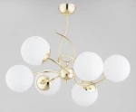 Lampa wisząca Tornado w kolorze złotym z sześcioma kulistymi kloszami z matowego szkła. Produkt zawieszony, z eleganckim, zakrzywionym ramieniem, idealny do nowoczesnych wnętrz. Wymiary i detale montażowe niewidoczne.