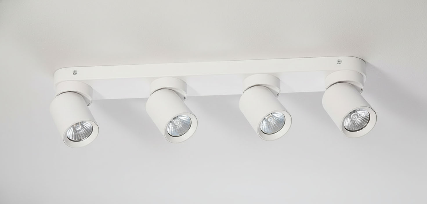 Biała lampa sufitowa Timo z czterema punktami świetlnymi. Każda lampa ma cylindryczny kształt i szklane klosze. Produkt zamontowany na prostokątnej podstawie, widoczny z góry, na jednolitym tle.