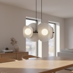 Lampa wisząca Elementi 4xG9 w kolorze czarnym i szarym, z czterema okrągłymi kloszami w białym, matowym szkle. Zawieszona na czarnych linkach w minimalistycznym wnętrzu, nad drewnianym stołem, z widokiem na okna.