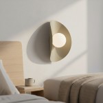 Kinkiet Fiero XL w kolorze mokka, z okrągłym źródłem światła, zamontowany na ścianie obok łóżka. Kształt lampy przypomina półkole, a jej faktura jest matowa. W tle widoczna stół nocny z kubkiem i pościel.
