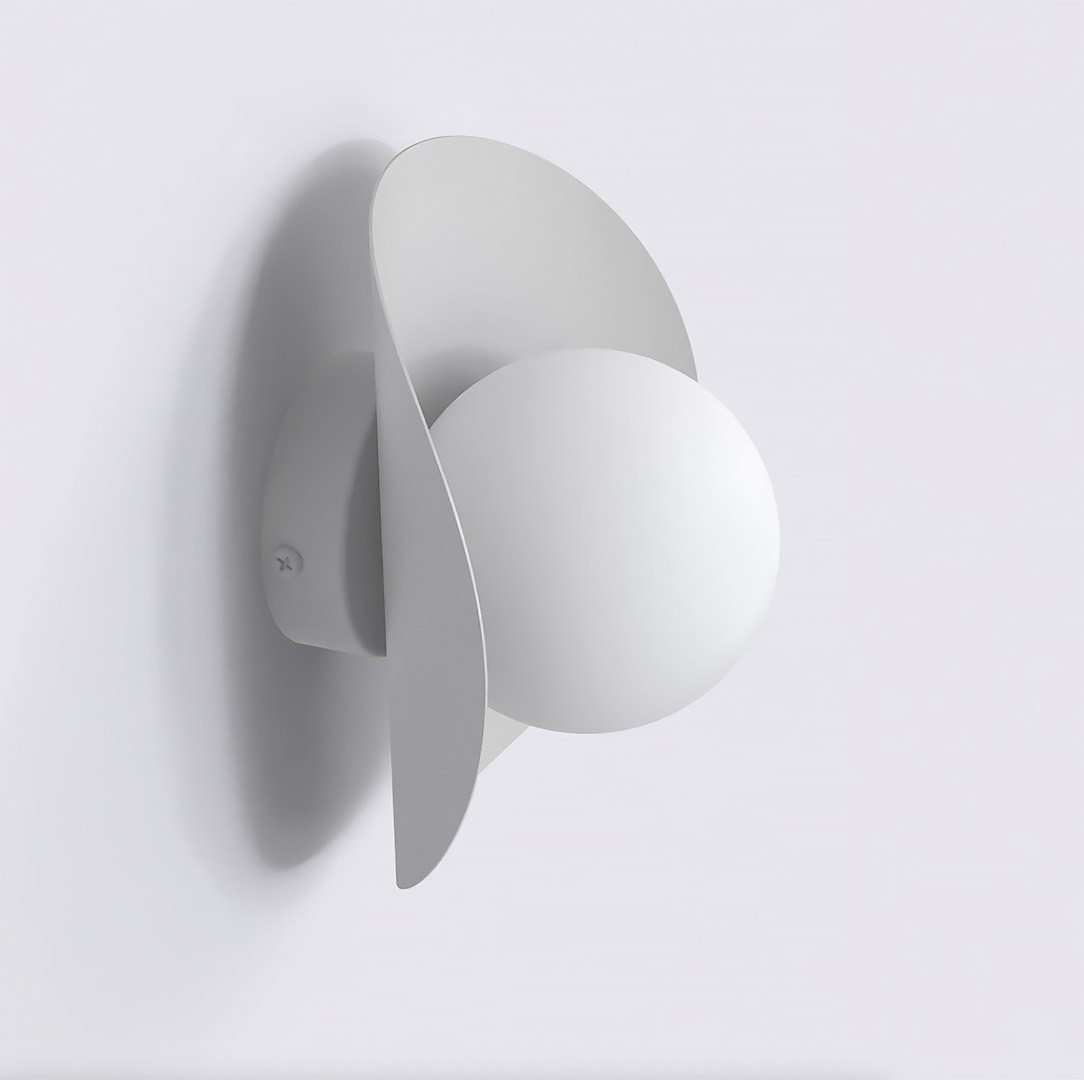 Kinkiet Fiero M w kolorze szarym, z okrągłą, białą oprawą i ozdobnymi, falistymi elementami. Montowany na ścianie, z widocznym mocowaniem. Lampa przeznaczona do żarówki G9.