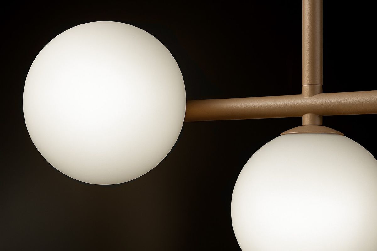 Beżowa lampa sufitowa Ardi z trzema kulistymi kloszami, wykonana z matowego szkła. Ujęcie z boku pokazuje dwa klosze zawieszone na metalowych ramionach. Klosze mają równą, gładką powierzchnię, a całość prezentuje nowoczesny design.