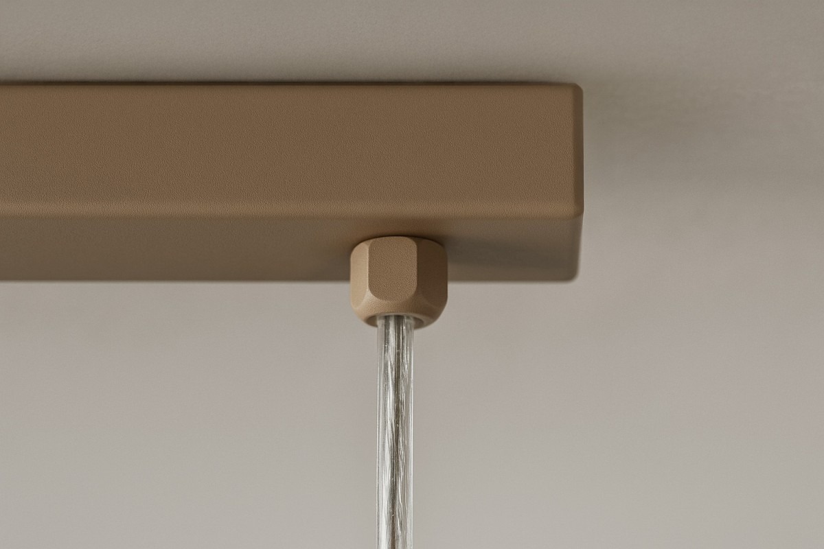 Beżowa lampa wisząca Lemo z 9 miejscami na żarówki G9. Ujęcie z góry, pokazujące detal mocowania z efektem tekstury. Lampa zawieszona na przezroczystym kablu, z prostokątną, matową podstawą w odcieniu beżowym.