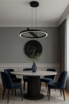 Lampa wisząca Tivoli 1xLED 24W CCT w kolorze czarnym, o okrągłym kształcie, zawieszona na cienkich linkach. Wyposażona w pierścień świetlny, umieszczona nad okrągłym stołem w jadalni, w otoczeniu niebieskich krzeseł i dekoracyjnej wazonu z roślinami.