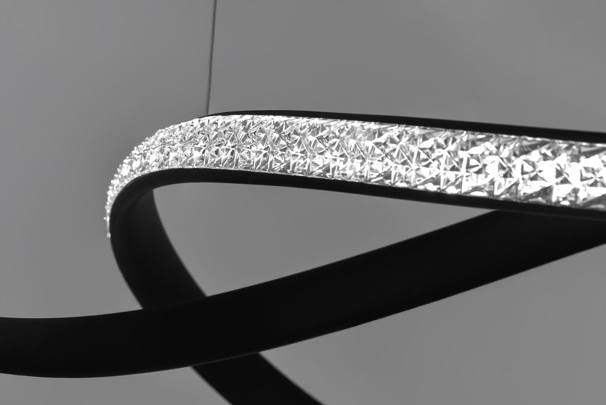 Lampa wisząca Fondi, czarna, z wbudowanym źródłem LED 40W. Zawiera elegancki pasek z kryształowymi detalami, w kształcie falującym. Ujęcie z boku, podkreślające unikalny design i fakturę.