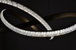 Złota lampa wisząca Fondi K-8237 z jedną diodą LED 40W, o nowoczesnym, spiralnym kształcie. Wykończenie z przezroczystymi kryształkami, które odbijają światło, wisząca w ciemnym tle, w zbliżeniu na detale.