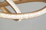 Lampa wisząca Fondi z jedną diodą LED 40W, w kolorze złotym. Okrągły metalowy stelaż z przezroczystym, teksturowanym akcentem, odbijającym światło. Widok z bliska, ukazujący szczegóły wykończenia.