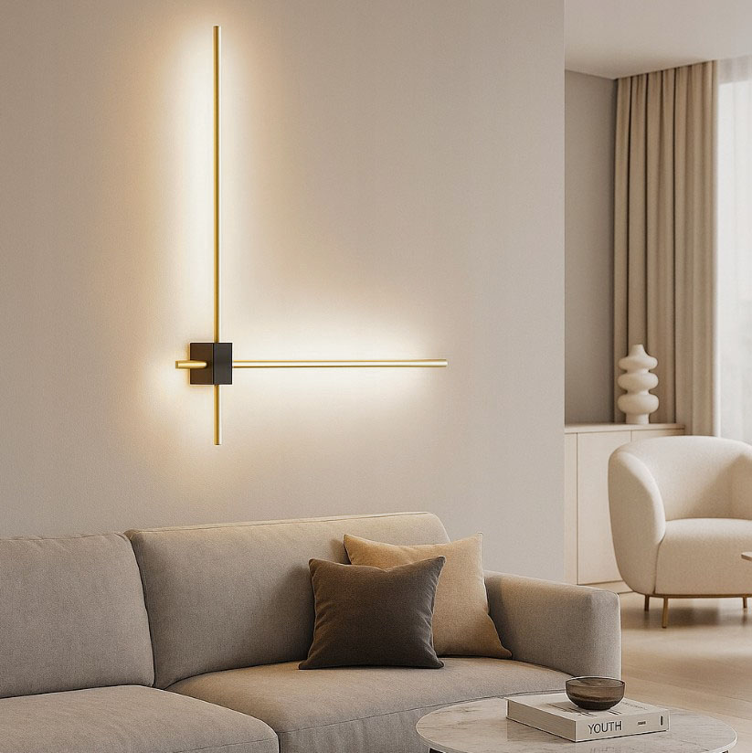Kinkiet LED 12W 4000K w kolorze złotym i czarnym, zamontowany na ścianie. Składa się z dwóch prostokątnych elementów świetlnych w formie linii. Otoczenie to nowoczesny salon z sofą i stolikiem. Tło w jasnym kolorze.