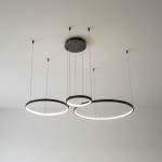 Lampa wisząca LED Hodo w kolorze czarnym, z trzema okrągłymi ramionami o średnicach 20/40/60 cm. Zawieszona na cienkich linkach, z możliwością regulacji wysokości. Wyposażona w pilot do zdalnego sterowania.