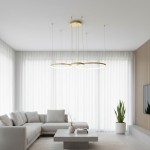 Lampa wisząca LED Hodo w kolorze złotym, w kształcie trzech okręgów, zawieszona na cienkich linkach. Wymiary 20/40/60 cm, moc 77W. Umieszczona w jasnym wnętrzu z kanapą i stolikiem, w otoczeniu roślin.