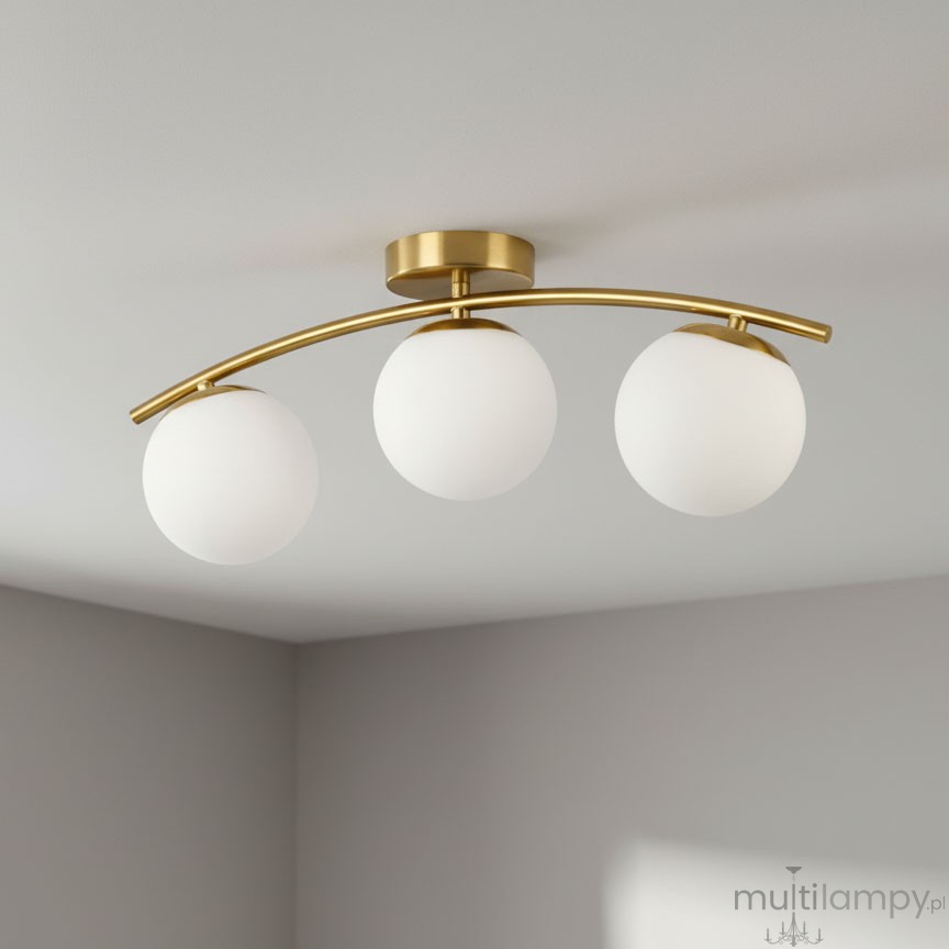 Lampa sufitowa Bali II z trzema kulistymi kloszami w białym kolorze, zamontowana na złotej, łukowatej oprawie. Ujęcie z dołu, pokazujące całość lampy na gładkim, jasnym tle.