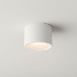 Lampa sufitowa Grandi w kształcie tuby, kolor biała, z jednym gwintem GX53, klasyfikacja IP54. Zainstalowana na suficie, z widocznych detali ma okrągły klosz, emitujący światło w dół. Prosta, minimalistyczna forma.